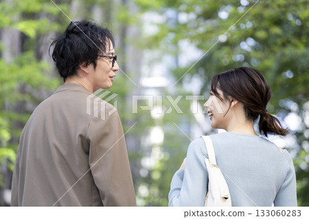 Smiling men and women in their 30s walking down the street Smiling men and women in their 30s walking down the street 133060283