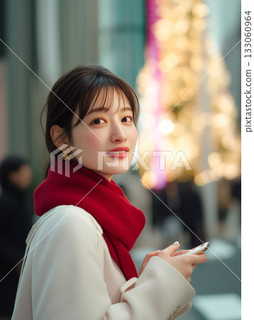 A woman meets up for a date in a town illuminated with Christmas lights during the Christmas season A woman meets up for a date in a town illuminated with Christmas lights during the Christmas season 133060964