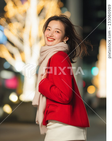 A woman meets up for a date in a town illuminated with Christmas lights during the Christmas season A woman meets up for a date in a town illuminated with Christmas lights during the Christmas season 133060989
