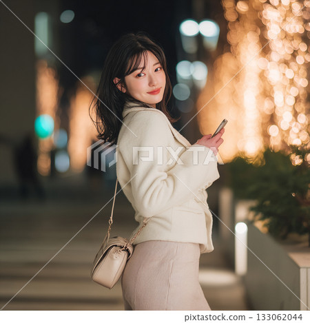 A woman meets up for a date in a town illuminated with Christmas lights during the Christmas season 133062044