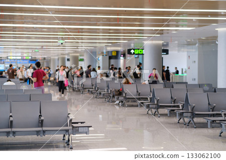 Busy airport terminal in the afternoon with travelers waiting for flights and checking in at counters Busy airport terminal in the afternoon with travelers waiting for flights and checking in at counters 133062100
