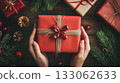 Giving gifts during the celebrating happy birthday. Woman hands holding a gift box. 133062633