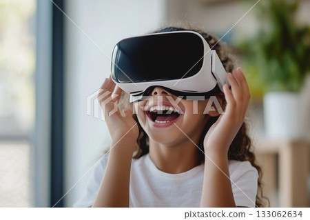 Portrait of happy smiling girl child person wearing virtual reality headset in room. Portrait of happy smiling girl child person wearing virtual reality headset in room. 133062634