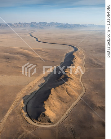 Dramatic volcanic basalt flow winds through the vast Mongolian desert landscape. Dramatic volcanic basalt flow winds through the vast Mongolian desert landscape. 133064066
