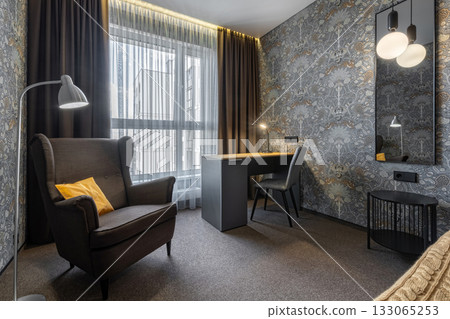 Cozy Bedroom Corner with Armchair Desk and Soft Lighting 133065253