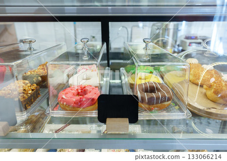 Colorful pastries displayed in a glass case at a local bakery during the afternoon 133066214