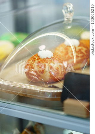 Freshly baked pastries displayed under glass in a cozy bakery counter 133066219