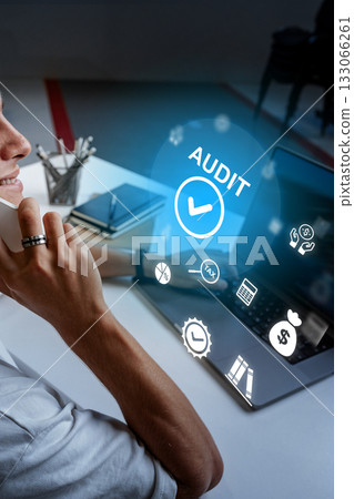 Professional man engages in audit work while on a phone call in an office setting 133066261