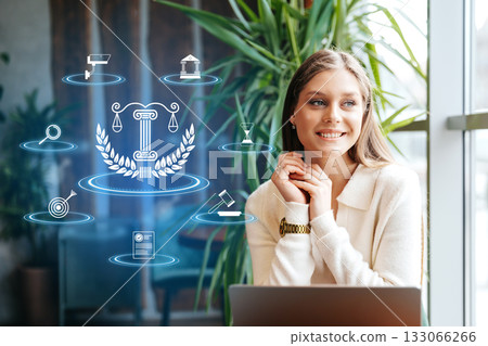 Young woman smiles near legal icons and plants indoors 133066266