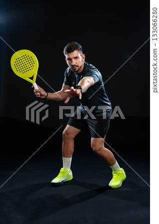 Dedicated athlete practices a racquet sport indoors with focus on technique and preparation 133066280