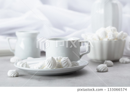 Vanilla meringue and coffee cup on a white marble table. 133066574