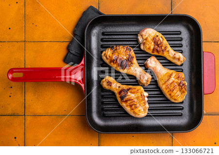 Succulent grilled drumsticks, marinated to perfection and served hot off the grill for a delightful dining experience. orange background. top view 133066721