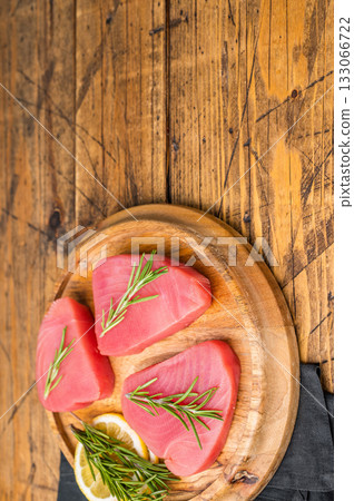 High quality raw tuna steak loin, perfect for a refreshing poke bowl or a delicious seared dish that impresses every time. wooden background. top view High quality raw tuna steak loin, perfect for a refreshing poke bowl or a delicious seared dish that impresses every time. wooden background. top view 133066722