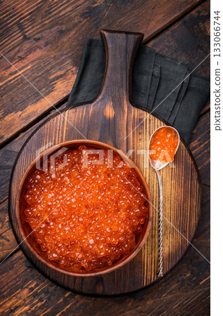 Delightful red caviar, a symbol of luxury and sophistication, ready to impress at your next gathering. wooden background. top view Delightful red caviar, a symbol of luxury and sophistication, ready to impress at your next gathering. wooden background. top view 133066744