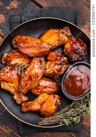 Deliciously sticky teriyakis sauce chicken wings, bursting with flavor, perfect for sharing at festive occasions or family dinners. wooden background. top view Deliciously sticky teriyakis sauce chicken wings, bursting with flavor, perfect for sharing at festive occasions or family dinners. wooden background. top view 133066747