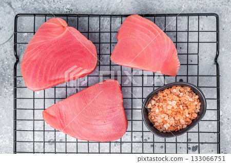 Premium raw tuna fillet steak, ideal for grilling or sashimi, a must-have for gourmet dishes and healthy meals. grey background. top view Premium raw tuna fillet steak, ideal for grilling or sashimi, a must-have for gourmet dishes and healthy meals. grey background. top view 133066751