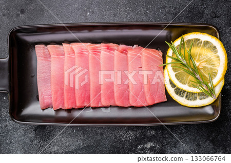Premium quality tuna sashimi, expertly cut for maximum tenderness and taste, perfect for sushi enthusiasts. black background. top view Premium quality tuna sashimi, expertly cut for maximum tenderness and taste, perfect for sushi enthusiasts. black background. top view 133066764