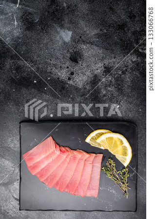 Premium quality tuna sashimi, ideal for a refreshing appetizer or light meal that delights the senses. black background. top view Premium quality tuna sashimi, ideal for a refreshing appetizer or light meal that delights the senses. black background. top view 133066768