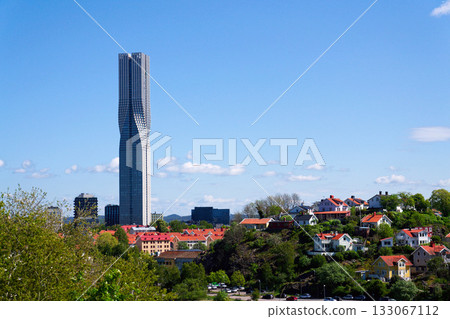 Colony of small wooden historic houses on the Slottsberget mountain with the tallest Scandinavian building Karlatornet skycraper in Lindholmen in background, Gothenburg, Sweden 133067112