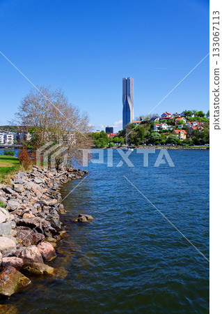 Colony of small wooden historic houses on the Slottsberget mountain with the tallest Scandinavian building Karlatornet skycraper in Lindholmen in background, Gothenburg, Sweden Colony of small wooden historic houses on the Slottsberget mountain with the tallest Scandinavian building Karlatornet skycraper in Lindholmen in background, Gothenburg, Sweden 133067113