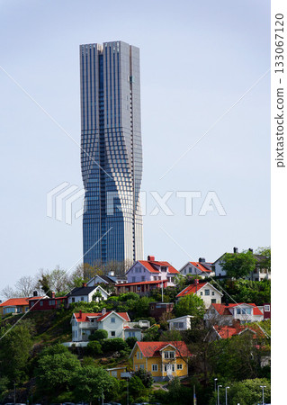 Colony of small wooden historic houses on the Slottsberget mountain with the tallest Scandinavian building Karlatornet skycraper in Lindholmen in background, Gothenburg, Sweden Colony of small wooden historic houses on the Slottsberget mountain with the tallest Scandinavian building Karlatornet skycraper in Lindholmen in background, Gothenburg, Sweden 133067120
