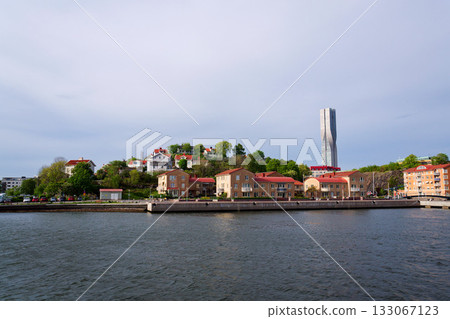 Colony of small wooden historic houses on the Slottsberget mountain with the tallest Scandinavian building Karlatornet skycraper in Lindholmen in background, Gothenburg, Sweden Colony of small wooden historic houses on the Slottsberget mountain with the tallest Scandinavian building Karlatornet skycraper in Lindholmen in background, Gothenburg, Sweden 133067123