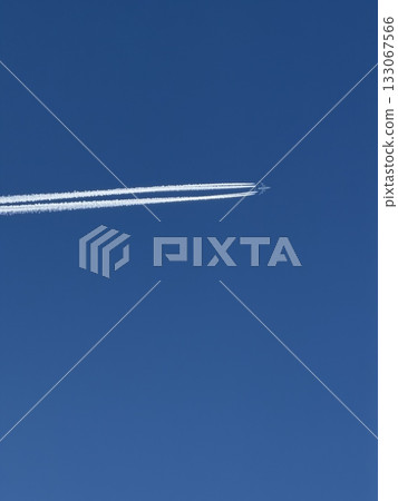 Airplane in the blue sky with contrails. 133067566