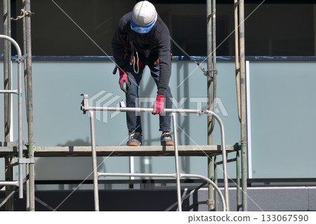 Construction site: Newly built apartment building: Temporary scaffolding being dismantled 133067590