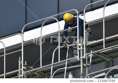 Construction site: Newly built apartment building: Temporary scaffolding being dismantled Construction site: Newly built apartment building: Temporary scaffolding being dismantled 133067594