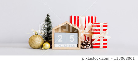 25 december. Christmas composition on colored background with a wooden calendar, with a gift box, toys, bauble copy space 133068001