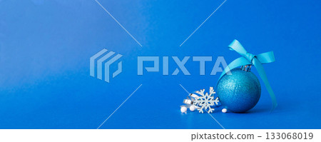Christmas ball on colored background. decoration bauble with ribbon bow with copy space Christmas ball on colored background. decoration bauble with ribbon bow with copy space 133068019