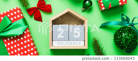 Christmas calendar 25 december. Christmas gift, fir branches, pine cones. Flat lay, top view. New Year decorations on a colored background Christmas calendar 25 december. Christmas gift, fir branches, pine cones. Flat lay, top view. New Year decorations on a colored background 133068043