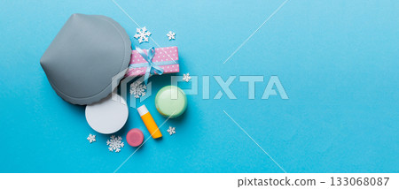 Christmas flat lay with makeup cosmetic products in cosmetic bag on colored background. Top view New year Beauty concept 133068087