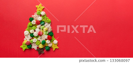 Christmas tree made from colored handmade ball decoration on colored background, view from above. New Year minimal concept with copy space 133068097