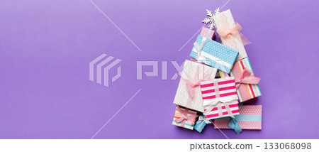 Christmas tree made of beautifuly wrapped presents on colored background, view from above. New Year gift box minimal concept with copy space Christmas tree made of beautifuly wrapped presents on colored background, view from above. New Year gift box minimal concept with copy space 133068098