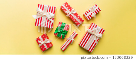 A lot of Christmas gift boxes in colored paper decorated on table, Top view close up. Many present New Year gift 133068329