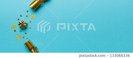 Christmas crackers with shiny confetti on color background, top view, copy space Christmas crackers with shiny confetti on color background, top view, copy space 133068336