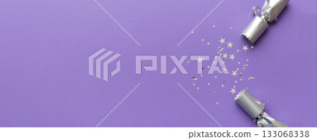 Christmas crackers with shiny confetti on color background, top view, copy space Christmas crackers with shiny confetti on color background, top view, copy space 133068338