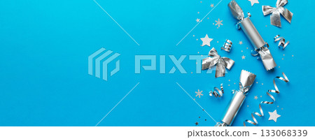 Christmas crackers with shiny confetti on color background, top view, copy space 133068339