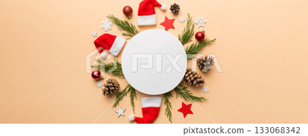 Flat lay Christmas composition. Round Paper blank, pine tree branches, christmas decorations on Colored background. Top view, copy space for text Flat lay Christmas composition. Round Paper blank, pine tree branches, christmas decorations on Colored background. Top view, copy space for text 133068342