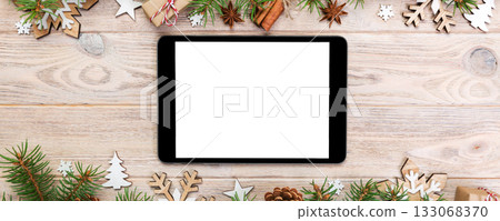 Digital tablet mock up with rustic Christmas wood background decorations for app presentation. top view with copy space Digital tablet mock up with rustic Christmas wood background decorations for app presentation. top view with copy space 133068370