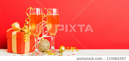 Champagne glasses and christmas decor on colored holiday background. Flat lay New Year decorations 133068397