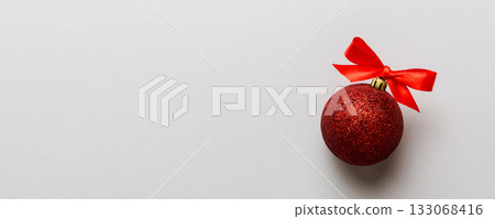 Christmas ball on colored background. decoration bauble with ribbon bow with copy space Christmas ball on colored background. decoration bauble with ribbon bow with copy space 133068416