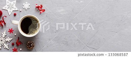 Delicious fresh festive morning coffee in a ceramic cup with little wrapped gifts, ornament and xmas toy. Cup of coffee and new year toys Delicious fresh festive morning coffee in a ceramic cup with little wrapped gifts, ornament and xmas toy. Cup of coffee and new year toys 133068587