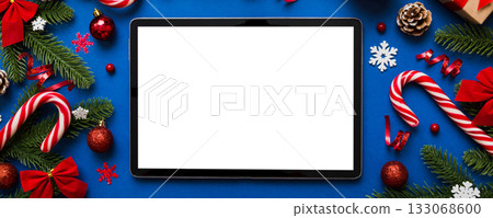 Top view of empty tablet on Christmas background made of new year decorand festive decorations. New year holiday concept. Mockup Top view of empty tablet on Christmas background made of new year decorand festive decorations. New year holiday concept. Mockup 133068600