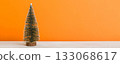 One small Christmas tree on colored background. new year decoration with copy space 133068617