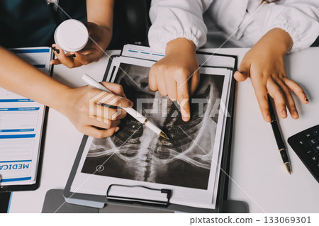 Group of doctors attending seminar in hospital lecture hall with senior physician giving medical presentation and professional training session on healthcare practices 133069301