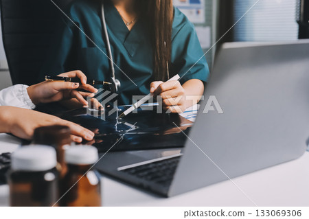 Group of doctors attending seminar in hospital lecture hall with senior physician giving medical presentation and professional training session on healthcare practices Group of doctors attending seminar in hospital lecture hall with senior physician giving medical presentation and professional training session on healthcare practices 133069306