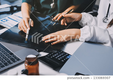 Group of doctors attending seminar in hospital lecture hall with senior physician giving medical presentation and professional training session on healthcare practices 133069307