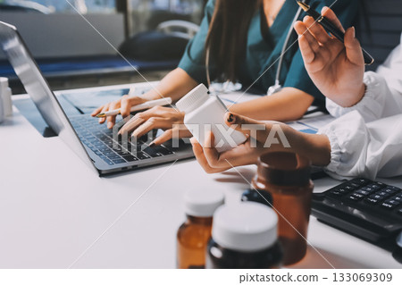 Group of doctors attending seminar in hospital lecture hall with senior physician giving medical presentation and professional training session on healthcare practices 133069309